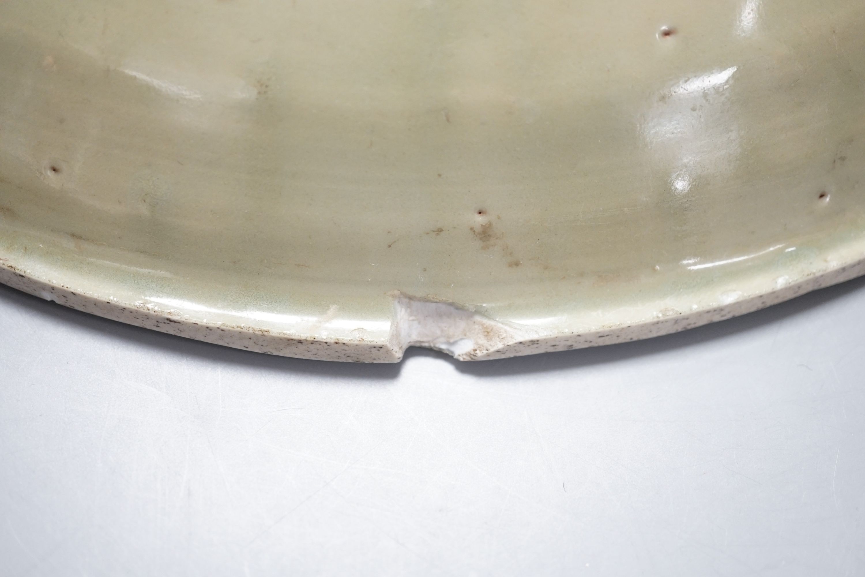 A Chinese Ming Longquan celadon dish, 15th/16th century, rim cut down, width 33cm